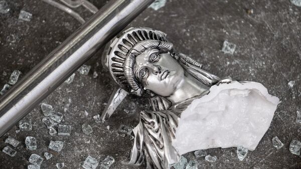 Разбитая фигура Статуи Свободы возле разграбленного сувенирного магазина в Нью-Йорке