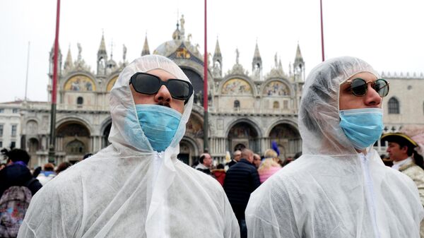 Туристы в защитных костюмах и масках во время карнавала в Венеции