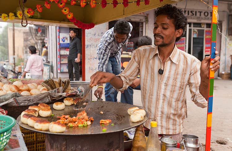 индиец готовит еду на улице