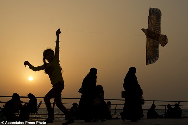A girl plays with her kite as visitors walk on the Red Sea beach, in Jiddah, Saudi Arabia. The country is planning to build a semi-autonomous luxury travel destination along its Red Sea coast that visitors can reach without a visa