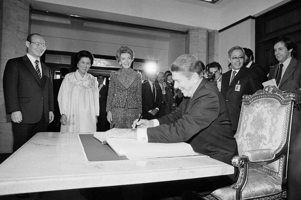 Рональд Рейган оставляет запись в гостевой книге в резиденции президента Южной Кореи в 1983-м. На заднем фоне — Чон Ду Хван и супруги глав государств